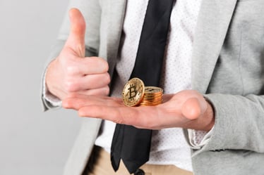 close-up-man-holding-stack-golden-bitcoins