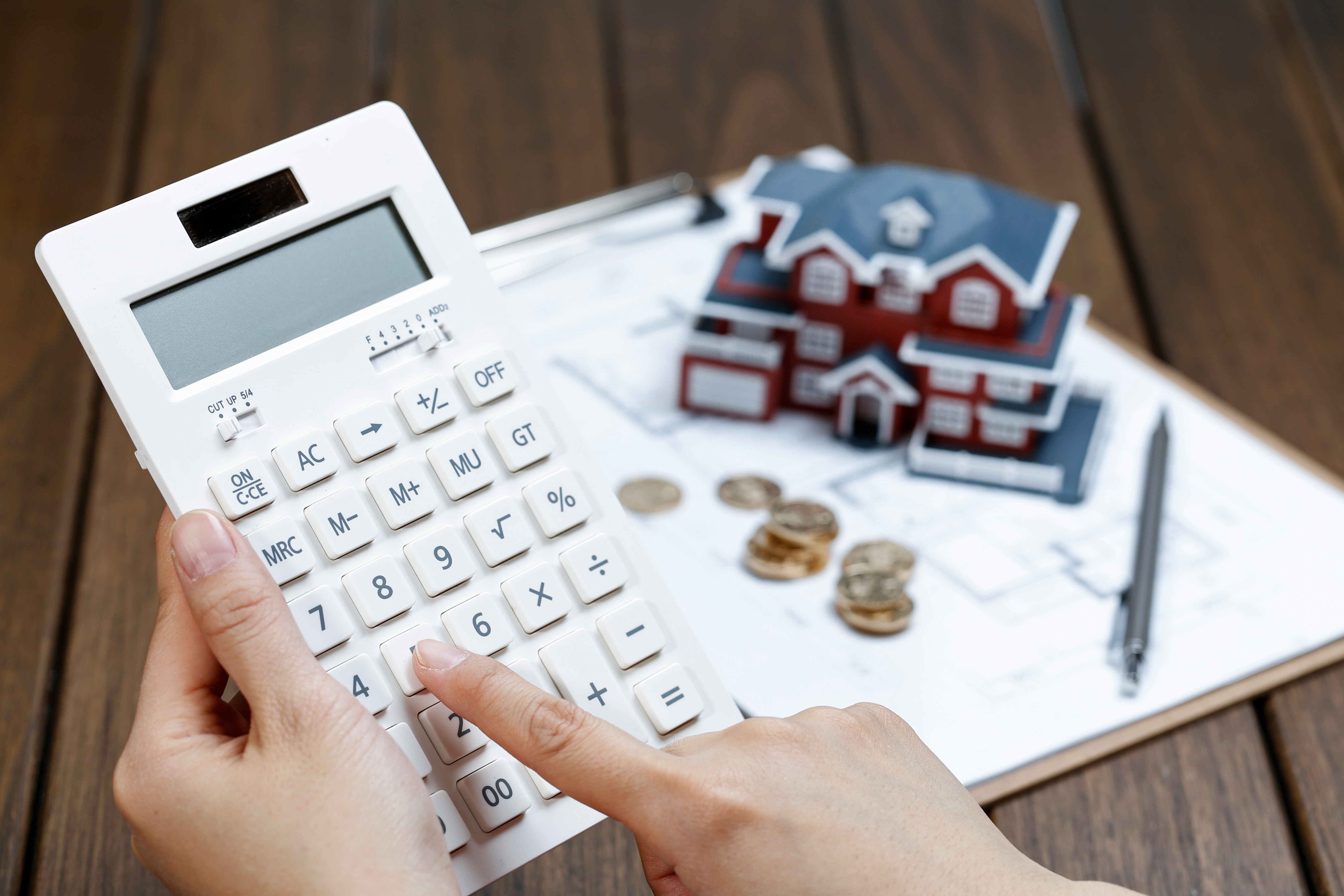 female-hand-operating-calculator-front-villa-house-model (1)-1